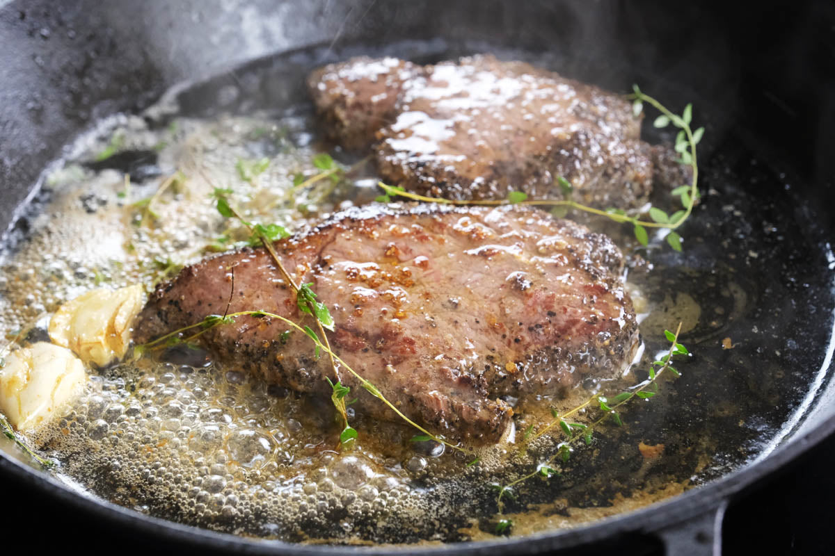 searing steak in a cast iron skillet